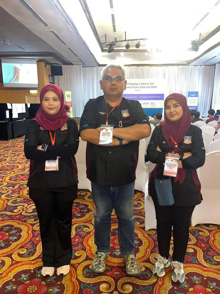 Tiga petugas MADOCS bergambar di hadapan sepanduk Privileging Course for Circumcision (Dorsal Slit) Part 2 di The Katerina Hotel, Batu Pahat