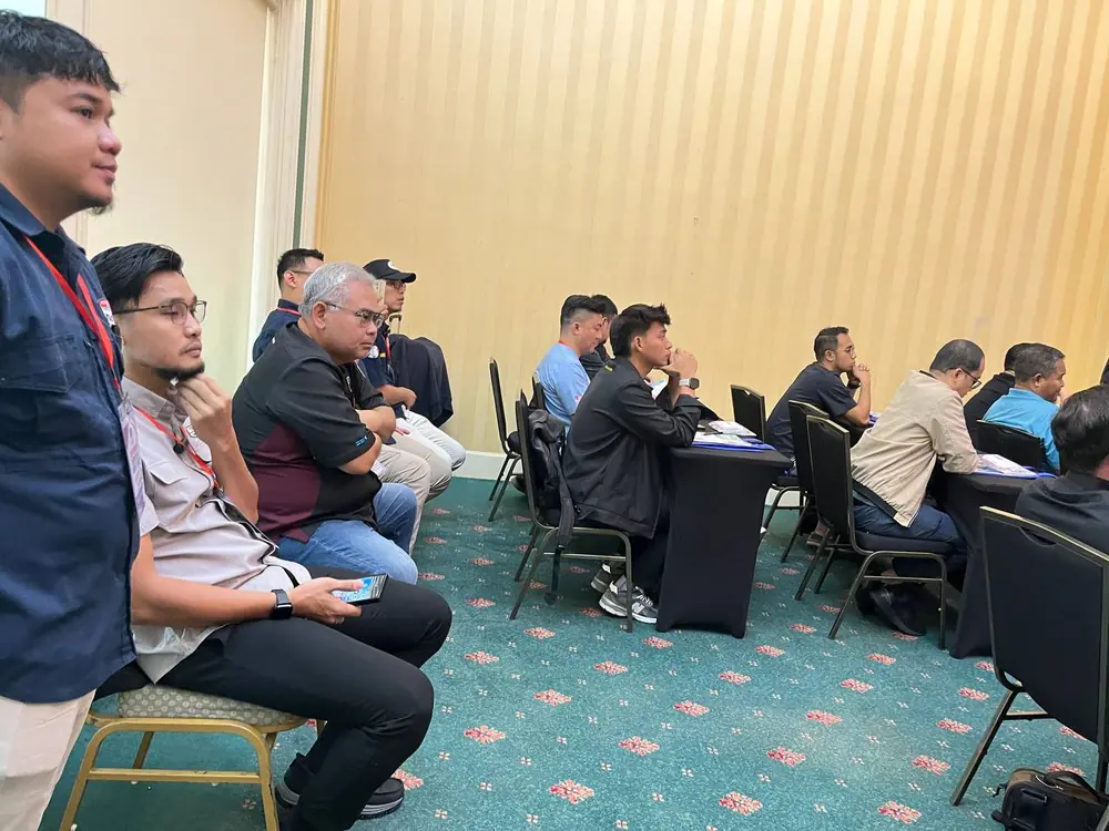 Peserta kursus PCC2-1 duduk di meja bulat sambil mengikuti sesi di dalam dewan