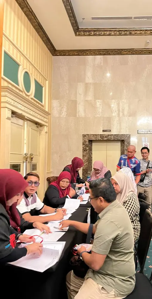 Kaunter pendaftaran PCC2-1 — urusetia menyemak borang peserta di meja pendaftaran The Katerina Hotel