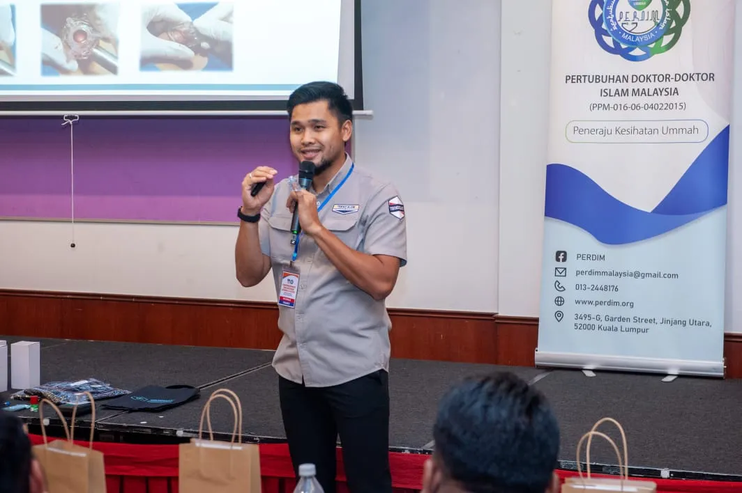 Pembentang bercakap di hadapan sepanduk CCC6