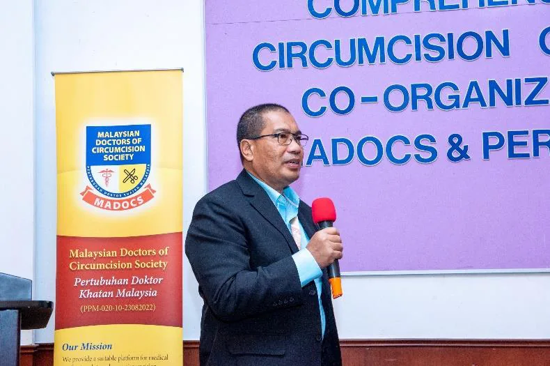 Speaker on stage at CCC 1 with MADOCS and PERDIM banners