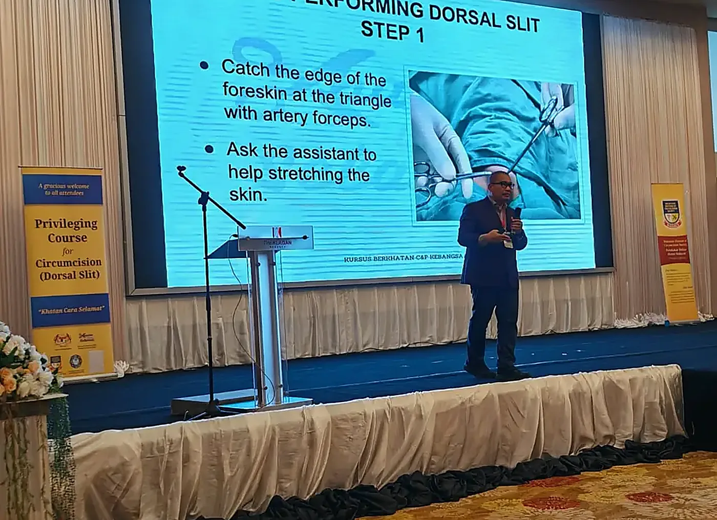Penceramah menerangkan langkah-langkah prosedur Dorsal Slit pada slaid semasa kursus PCC di Kota Kinabalu