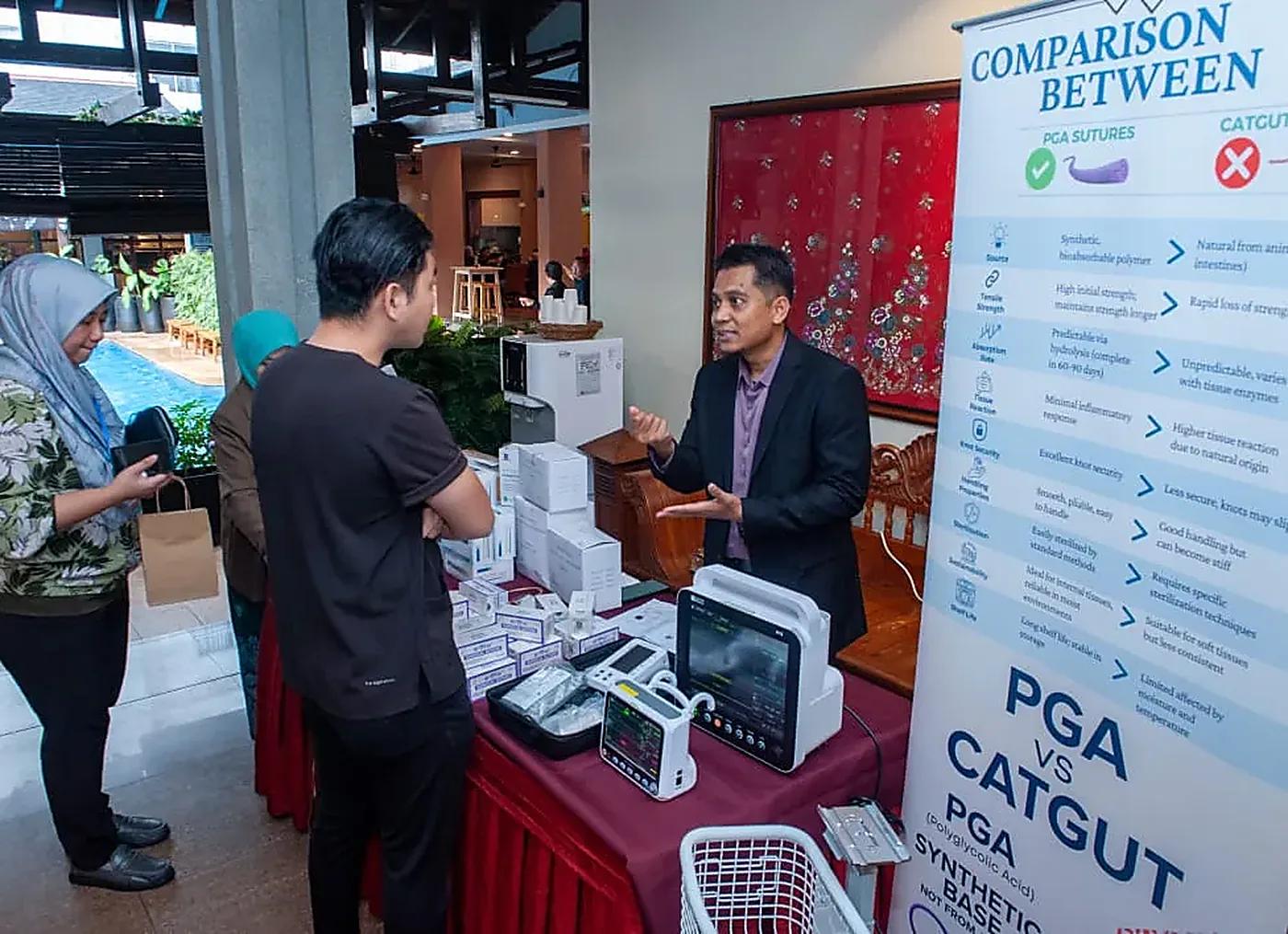 Booth pameran peranti berkhatan dengan sepanduk perbandingan kaedah semasa program CME MADOCS